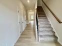 Bright entryway with wood-look flooring and carpeted stairs at 76 Commons Cir, Clayton, NC 27520
