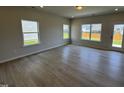 Bright living area showcasing wood-look floors, natural light from surrounding windows, and access to the backyard at 76 Commons Cir, Clayton, NC 27520