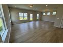 Spacious and bright living room featuring wood-look floors and large windows offering ample natural light at 76 Commons Cir, Clayton, NC 27520