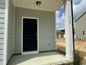 A modern front door with black hardware is framed by white columns and brick accents at 765 Portland Rose Dr, Knightdale, NC 27545