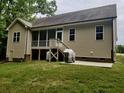 Exterior view of a house featuring a screened porch, patio, and well-maintained lawn at 79 Hillgrove Dr, Willow Springs, NC 27592