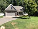 Charming home with a stone-accented garage, inviting front porch, and a beautiful shade tree at 79 Hillgrove Dr, Willow Springs, NC 27592