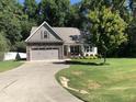 Charming home with a stone-accented garage, inviting front porch, and a well-manicured lawn at 79 Hillgrove Dr, Willow Springs, NC 27592