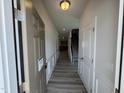 Inviting entryway with gray wood flooring, neutral walls, and trimwork, leading to other rooms in the home at 84 Commons Cir, Clayton, NC 27520