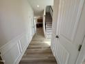 Inviting hallway featuring wood-look flooring and stairs leading to the upper level at 84 Commons Cir, Clayton, NC 27520