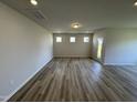 Bright, empty living room with recessed lights, modern light wood flooring, and a door to the backyard at 84 Commons Cir, Clayton, NC 27520