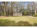 Charming single-story home nestled amongst mature trees, with a spacious front lawn at 900 Cricket Knoll Rd, Fuquay Varina, NC 27526