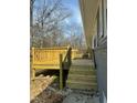 Close-up of the new wooden deck featuring a black railing and steps leading to the yard at 915 Knight Dr, Durham, NC 27712