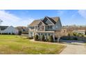 Landscaped yard showcasing a well-maintained lawn, mature trees, and a gray two-story home at 1036 Butterfly Cir, Wake Forest, NC 27587