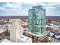 A modern high-rise stands tall, complemented by the surrounding city landscape and a clear blue sky at 110 N Corcoran St # 2302, Durham, NC 27701