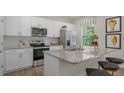 Modern kitchen featuring white cabinets, granite countertops, stainless steel appliances, and a breakfast bar at 1104 Ursa Major Ct, Wendell, NC 27591