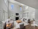 Bright, virtually staged living room with high ceilings, fireplace, built-in shelves and modern furniture at 117 Pierce Rd, Garner, NC 27529