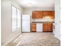 Clean kitchen featuring tile flooring, white appliances, and wood cabinetry at 121 Westview Dr # 43, Carrboro, NC 27510
