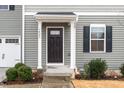 Close up on the front door of a two-story home with gray siding and a white garage door at 1423 Bridgewater Dr, Durham, NC 27704