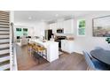Bright, open-concept kitchen featuring white cabinets, stainless steel appliances, and a large island with seating at 1546 Crescent Townes Way, Raleigh, NC 27604