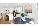 Modern kitchen with white cabinets, stainless steel appliances, and an adjacent dining area with round table at 1546 Crescent Townes Way, Raleigh, NC 27604