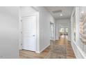Bright hallway with wood floors featuring white trim, doors, and neutral walls, enhancing the home's design at 1914 Malvina Ct, Graham, NC 27253