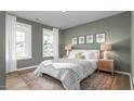 Stylishly decorated main bedroom featuring a large bed, decorative wall art, and bright windows with light curtains at 1914 Malvina Ct, Graham, NC 27253