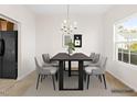 Dining room with black table and gray chairs, complemented by natural light and a modern chandelier at 2 Bolter Ct, Durham, NC 27704