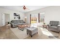 Bright living room with neutral decor, featuring a gray sofa, chair, and access to a patio at 2 Bolter Ct, Durham, NC 27704