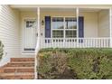 Inviting front porch with brick steps, white railings, blue shutters, and a charming entry door at 201 Alice Dr, Garner, NC 27529