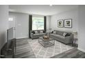 Inviting living room with neutral tones, comfortable sofas, and a stylish geometric patterned rug at 221 N Coral Bells Way, Four Oaks, NC 27524