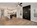 Spacious living room featuring sleek wood floors, a modern ceiling fan, and an open layout to the kitchen at 2212 Edwin Ave # A, Durham, NC 27705