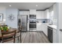 Modern kitchen featuring stainless steel appliances, white cabinets, light countertops, and hardwood flooring at 231 N Coral Bells Way, Four Oaks, NC 27524