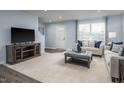 Spacious living room with plush carpeting, neutral-toned furniture, modern décor and abundant natural light at 231 N Coral Bells Way, Four Oaks, NC 27524
