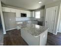 Modern kitchen with granite countertops, stainless steel appliances, and a center island at 26 Harvest Hills Ln, Dunn, NC 28334
