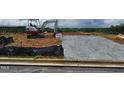 New home construction site showing foundation work and an excavator in a partially developed area at 26 Northwood Dr, Fuquay Varina, NC 27526