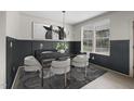 Elegant dining room with wainscoting, stylish chandelier, modern furniture, and large windows at 3281 Philips Chapel Rd, Haw River, NC 27258