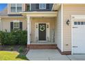 Close-up of a charming front entryway with a welcoming wreath and decorative welcome sign at 36 Deep Woods Ln, Cameron, NC 28326
