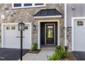 Close up shot of stone front facade, black front door and 1-car garage at 509 Sherron Rd # 36, Raleigh, NC 27703