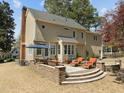 Backyard view features a spacious patio with stone retaining wall, outdoor furniture, and a built-in grill at 5125 Salinas Ct, Holly Springs, NC 27540