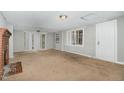 Bright living room with large windows, carpeted floors, and a brick fireplace at 5324 Rock Quarry Rd, Raleigh, NC 27610