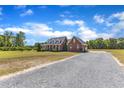 Charming two-story brick home featuring a welcoming front porch and a gravel driveway at 5595 Godwin Lake Rd, Benson, NC 27504