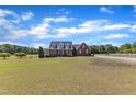 Charming two-story brick home featuring a welcoming front porch, manicured lawn, and a long driveway at 5595 Godwin Lake Rd, Benson, NC 27504
