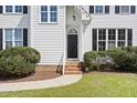 Inviting front door with brick steps and manicured bushes, showcasing the home's entrance at 5745 Spence Farm Rd, Holly Springs, NC 27540