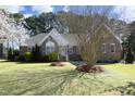 Charming brick home featuring manicured lawn, blossoming tree, and attractive landscaping at 6521 Vintage Ridge Ln, Fuquay Varina, NC 27526