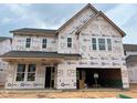 A new two-story home with unfinished exterior featuring a two-car garage and visible construction materials at 779 Old Station Pointe, Angier, NC 27501