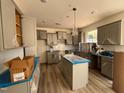 New kitchen features ample cabinet storage, large island with a sink, modern hardware, and tiled backsplash at 779 Old Station Pointe, Angier, NC 27501