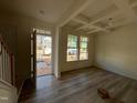 Bright living room showcasing hardwood floors, tray ceiling detail, and large windows overlooking the front yard at 779 Old Station Pointe, Angier, NC 27501