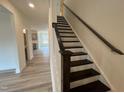 Elegant staircase with dark wood railing and white risers, adding a touch of sophistication at 779 Old Station Pointe, Angier, NC 27501
