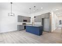 Open-concept kitchen with gray cabinets, stainless steel appliances, and a blue island with pendant lighting at 812 East St, Smithfield, NC 27577