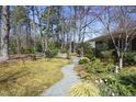 Expansive backyard with lush lawn, mature trees, stone path, and manicured landscaping at 817 Old Mill Rd, Chapel Hill, NC 27514