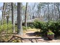 Inviting brick pathway leading to a beautifully landscaped home surrounded by mature trees at 817 Old Mill Rd, Chapel Hill, NC 27514