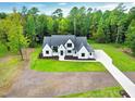 Aerial view of a modern two-story home with a large lot, manicured lawn, and a long driveway at 92 Bluffside Ct, Pittsboro, NC 27312