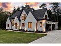 Beautiful two-story home with a three-car garage, modern exterior design, and lush green lawn at 92 Bluffside Ct, Pittsboro, NC 27312