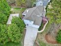 Stunning aerial view of a light blue two-story home with a basketball court and driveway leading to a three-car garage at 101 Goldenthal Ct, Cary, NC 27519